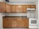 This kitchen includes wood cabinets, double sinks, and a white oven at 2633 Yale Rd, South Daytona, FL 32119