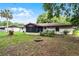 View of the house, including the screened in porch from the backyard, with a fire pit at 270 Sandyhook Ln, Deland, FL 32724