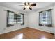 Cozy bedroom with hardwood floors, a ceiling fan, and two windows dressed in light curtains at 270 Sandyhook Ln, Deland, FL 32724