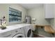Bright laundry room includes washer, dryer, water heater, sink, storage, and window at 270 Sandyhook Ln, Deland, FL 32724