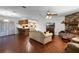 Inviting living room featuring a brick fireplace, wood floors, and an open layout into the kitchen at 270 Sandyhook Ln, Deland, FL 32724