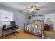 A bright main bedroom featuring two windows, a ceiling fan, light blue walls, and hardwood floors at 270 Sandyhook Ln, Deland, FL 32724
