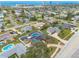 Wide aerial view shows a community with tree-lined streets, swimming pools, and proximity to the ocean and city buildings at 2724 N Halifax Ave, Daytona Beach, FL 32118