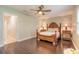Elegant bedroom featuring hardwood floors, a ceiling fan, and a view to the bathroom at 2724 N Halifax Ave, Daytona Beach, FL 32118