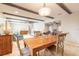 Open-concept dining room with ceiling beams, adjacent living spaces, and travertine tile floors at 2724 N Halifax Ave, Daytona Beach, FL 32118