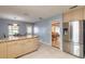 Bright kitchen with tile floors, stainless fridge, granite countertops and island, with open flow to dining area at 2724 N Halifax Ave, Daytona Beach, FL 32118
