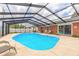 Screened-in pool area with brick patio and lounging chairs, perfect for outdoor relaxation at 2724 N Halifax Ave, Daytona Beach, FL 32118