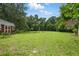 Spacious backyard featuring a large grassy area, mature trees, and custom horseshoe setup at 2950 Ragis Rd, Edgewater, FL 32132