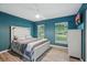 Bedroom with beautiful blue walls, updated floors, a ceiling fan, and two bright windows at 2950 Ragis Rd, Edgewater, FL 32132