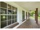 Spacious front porch with wooden floors, white trim and views of the surrounding greenery at 2950 Ragis Rd, Edgewater, FL 32132