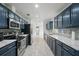 Galley kitchen with stylish blue cabinets, white countertops, and stainless steel appliances at 2950 Ragis Rd, Edgewater, FL 32132