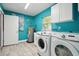 Laundry room with turquoise walls, a utility sink, and new washer and dryer at 2950 Ragis Rd, Edgewater, FL 32132