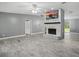 Open living room with a striking stone fireplace, vaulted ceilings, and wood-look tile flooring at 2950 Ragis Rd, Edgewater, FL 32132