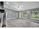 Light-filled living room with wood-look tile, large windows, and a view of the yard at 2950 Ragis Rd, Edgewater, FL 32132