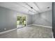 Bright living room features gray walls, wood-look floors, and sliding glass doors to the backyard at 2950 Ragis Rd, Edgewater, FL 32132