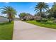Charming single-story home featuring a manicured lawn, mature palm trees, and a detached garage at 3 Pine Meadow Ct, Debary, FL 32713