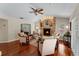 Inviting living room with hardwood floors, brick fireplace, and comfortable seating arrangement at 3 Pine Meadow Ct, Debary, FL 32713