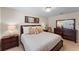 Well-lit main bedroom with a comfortable bed, lamps, and a dresser with a mirror at 3 Pine Meadow Ct, Debary, FL 32713