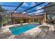 Backyard showcasing a large pool with blue water, spa, and screened enclosure, surrounded by brick pavers at 3 Pine Meadow Ct, Debary, FL 32713