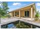 Backyard with a covered patio and brick pavers surrounding a pond filled with colorful Koi fish at 31 Abacus Ave, Ormond Beach, FL 32174