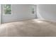 Neutral bedroom with carpet floors and lots of natural light streaming through two large windows at 31 Abacus Ave, Ormond Beach, FL 32174