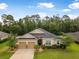 Charming single-story home with stone accents, lush landscaping, and a two-car garage at 31 Abacus Ave, Ormond Beach, FL 32174