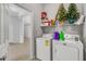 Functional laundry room with front-loading washer and dryer, shelving, and convenient access to living areas at 31 Abacus Ave, Ormond Beach, FL 32174