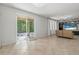 Bright living room featuring neutral tile floors, a decorative entertainment center, and sliding glass doors to the backyard at 31 Abacus Ave, Ormond Beach, FL 32174