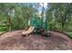 Community playground with slides and climbing structures surrounded by trees and mulch at 31 Abacus Ave, Ormond Beach, FL 32174