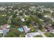 Drone shot of a quiet neighborhood lined with trees and homes of varied styles and backyard pools at 3117 Pine Tree Dr, Edgewater, FL 32141