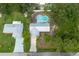 A high angle shot of a home with backyard swimming pool surrounded by lush greenery in the back at 3117 Pine Tree Dr, Edgewater, FL 32141