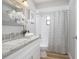Bathroom featuring a granite countertop, flower accent, and shower with striped curtain at 3117 Pine Tree Dr, Edgewater, FL 32141