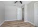Bright bedroom featuring wood-look flooring, ceiling fan, and white trim at 3117 Pine Tree Dr, Edgewater, FL 32141