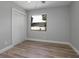 Bedroom with wood-look flooring, gray walls, and a window view of the outside at 3117 Pine Tree Dr, Edgewater, FL 32141