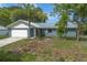 Charming single-story home featuring a metal roof, attached garage, and well-maintained front lawn with landscaping at 3117 Pine Tree Dr, Edgewater, FL 32141