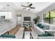 Open-concept living room with hardwood flooring, white furniture, and connection to the kitchen and hall at 3117 Pine Tree Dr, Edgewater, FL 32141