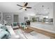 Spacious living room with hardwood floors, ceiling fan, and an open layout to the kitchen and dining area at 3117 Pine Tree Dr, Edgewater, FL 32141