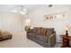 Bright living room features tile flooring, a ceiling fan, and a comfortable sofa with stylish throw pillows at 325 Homewood Ave # 10I, Debary, FL 32713
