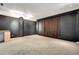 Finished carpeted basement featuring a wet bar, black accent walls, and theater curtain at 3428 Longleaf Rd, Ormond Beach, FL 32174