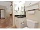 Cozy bathroom featuring a white sink and toilet, and a black countertop, providing essential amenities at 3428 Longleaf Rd, Ormond Beach, FL 32174