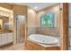 Beautiful bathroom featuring a soaking tub, large window, and tiled accents at 3428 Longleaf Rd, Ormond Beach, FL 32174