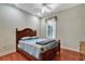 This bedroom features a wooden bed frame, a ceiling fan, and a window with curtains at 3428 Longleaf Rd, Ormond Beach, FL 32174