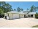 Exterior of large home showcasing long driveway and attached garages on a large lot at 3428 Longleaf Rd, Ormond Beach, FL 32174