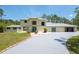 Two-story house with stucco exterior, white gravel, palm tree, green trim, and long driveway at 3428 Longleaf Rd, Ormond Beach, FL 32174