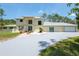 Front exterior of house, including a long driveway and a three-car garage at 3428 Longleaf Rd, Ormond Beach, FL 32174