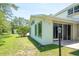 View of the house exterior featuring multiple windows, sliding glass doors, and a well-maintained lawn at 3428 Longleaf Rd, Ormond Beach, FL 32174