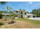 Two-story home with a manicured lawn, palm tree, and a long driveway at 3428 Longleaf Rd, Ormond Beach, FL 32174