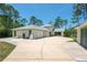 Exterior of large home showcasing lush backyard, long driveway and attached garages at 3428 Longleaf Rd, Ormond Beach, FL 32174