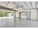Large garage with epoxy flooring, cabinets, storage shelves, and open garage door at 3428 Longleaf Rd, Ormond Beach, FL 32174