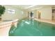 A wide shot of the indoor pool and jacuzzi area with multiple windows and tile accents at 3428 Longleaf Rd, Ormond Beach, FL 32174